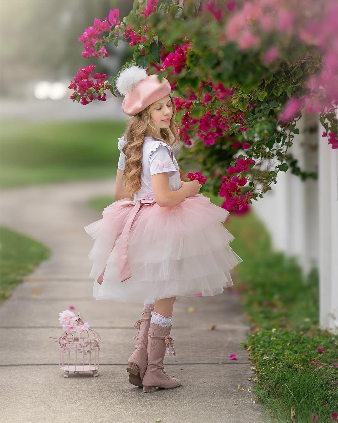 Little girl in pink ombré tutu skirt with soft layered tulle and satin bow, styled for a dreamy garden photoshoot.