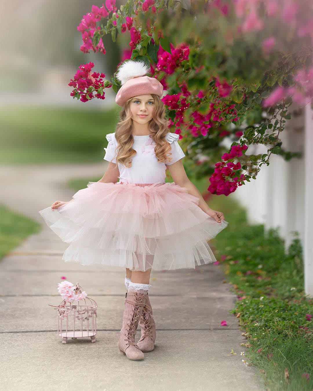 Girl wearing pink ombré tutu skirt with layered blush and ivory tulle, styled for an elegant outdoor photoshoot.