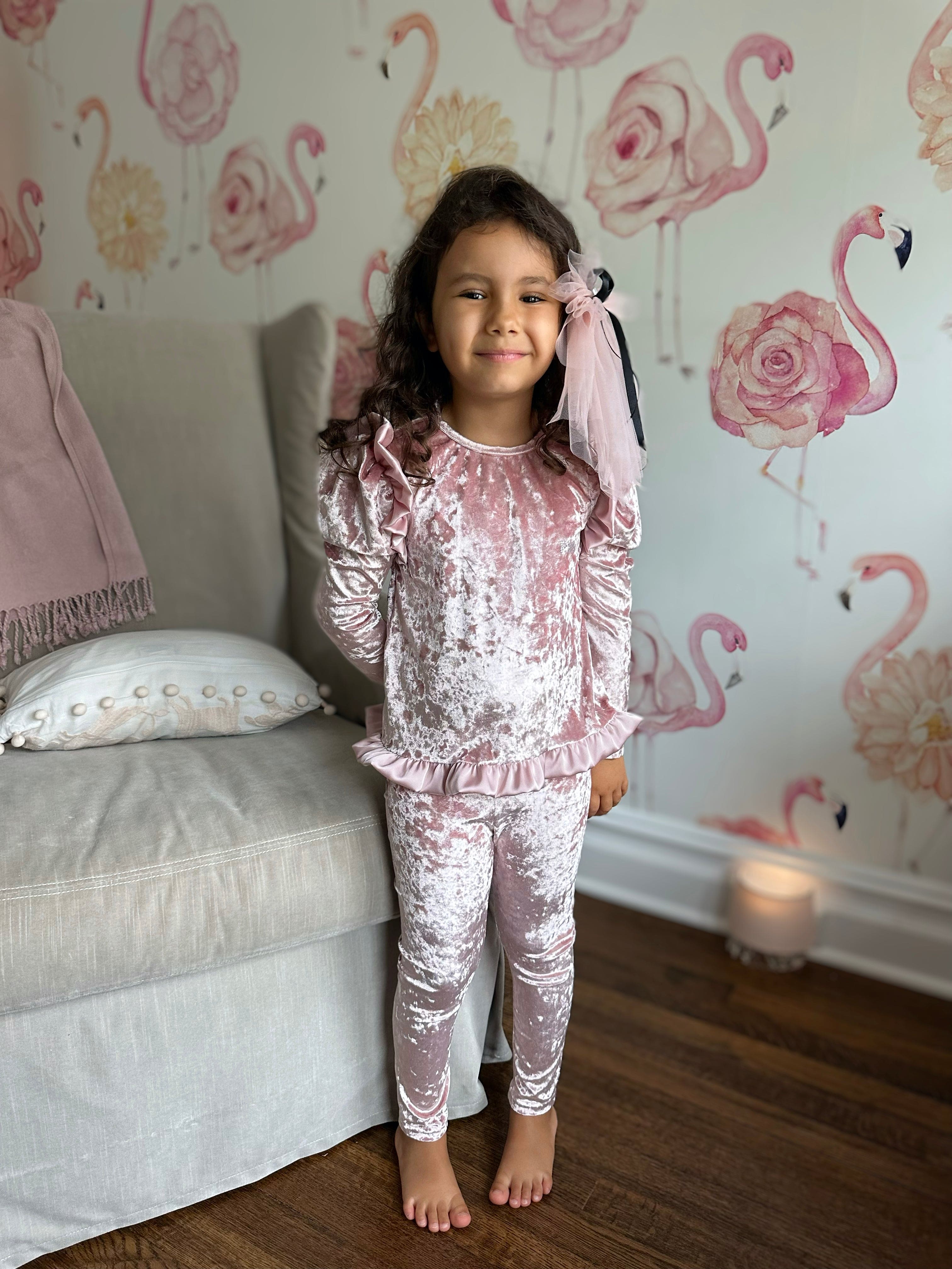 Little girl wearing pink velour lounge set with ruffle shoulder detail and matching leggings, cozy luxury girls lounge outfit