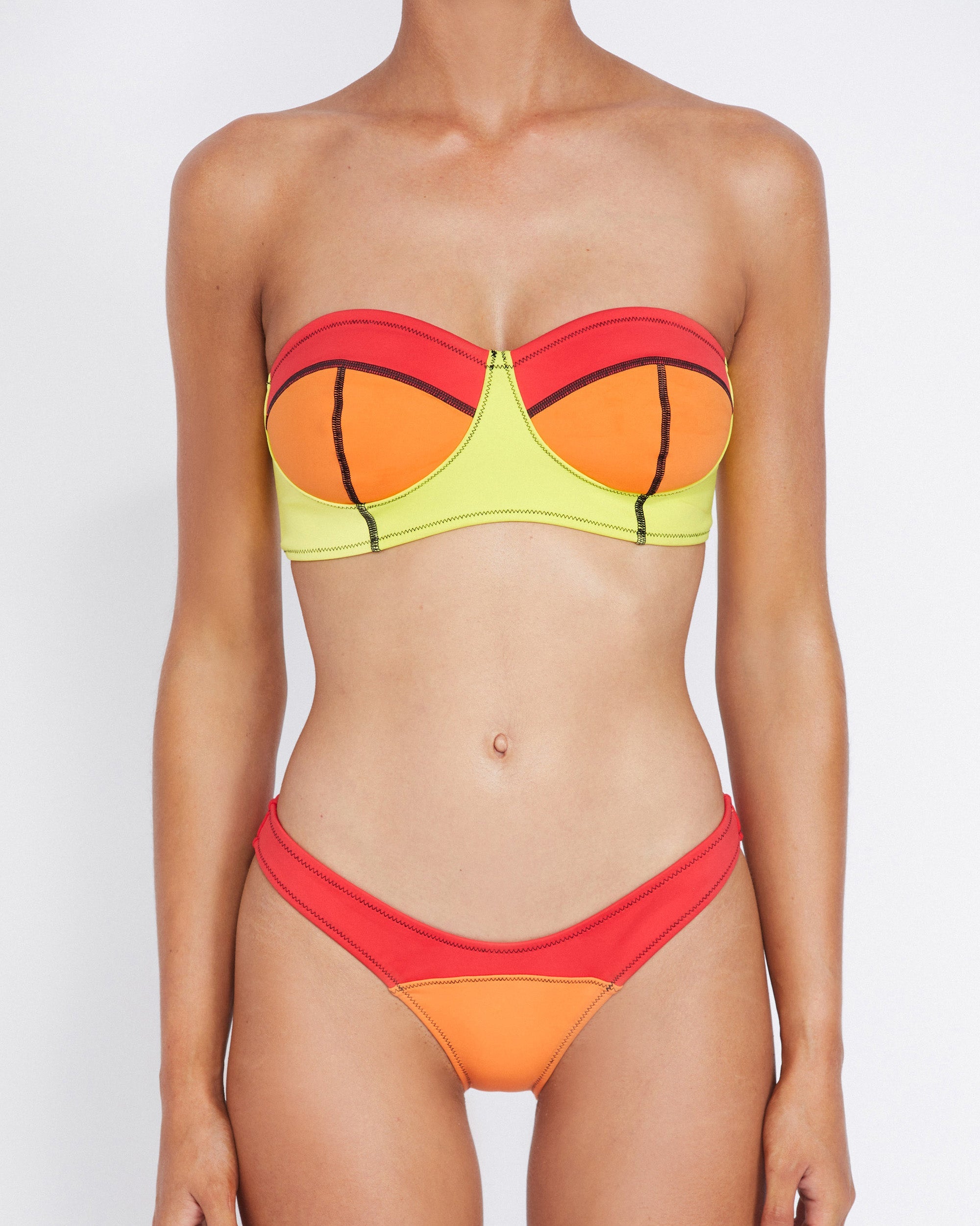 Studio image of model wearing the Neo Bandeau in Pipeline, showcasing its strapless shape and vibrant color blocks.