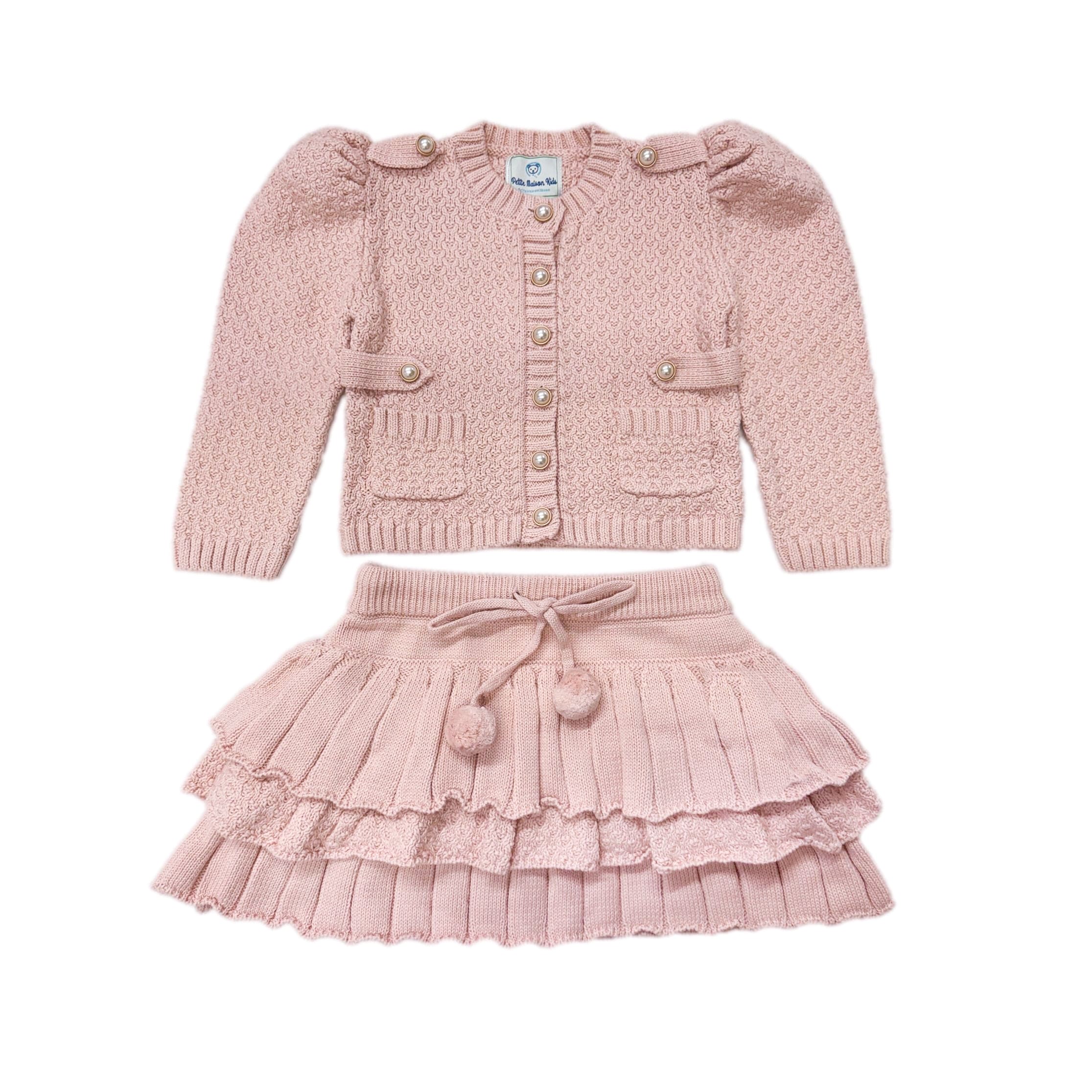 Julie petal pink cotton knit top and skirt set for girls featuring a button-down cardigan with pearl buttons, puff sleeves, and a ruffle pom-pom skirt.