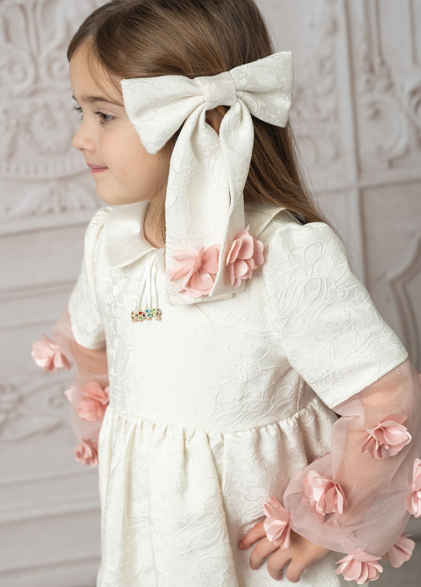 Girl wearing ivory cherry blossom hair bow with pink flower details, styled with a dress for an elegant look