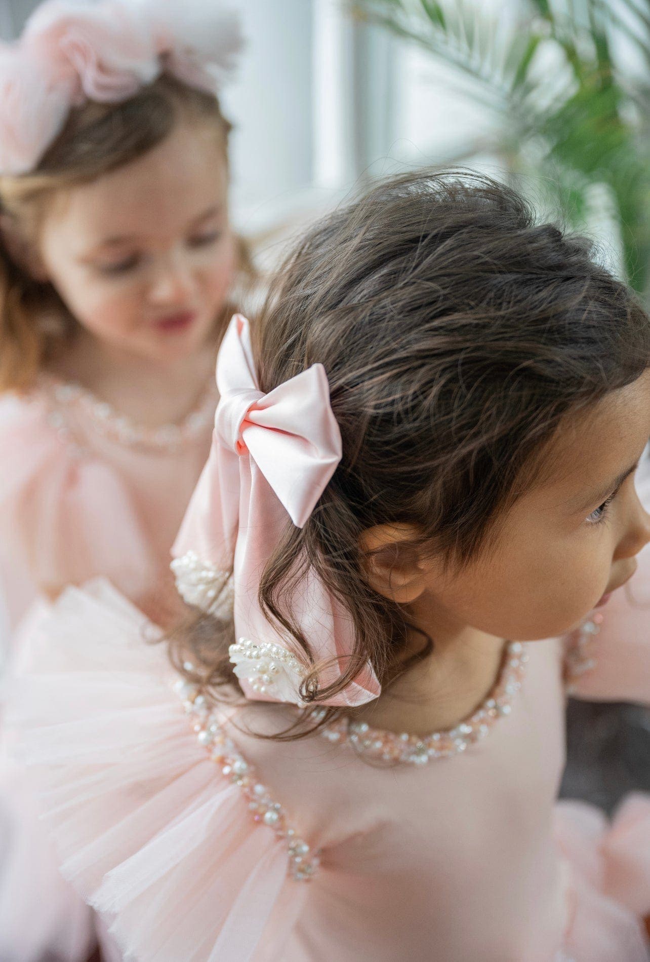 Young girl styling the Ballet pink Anise Satin Embroidered Hair Bow with pearl details