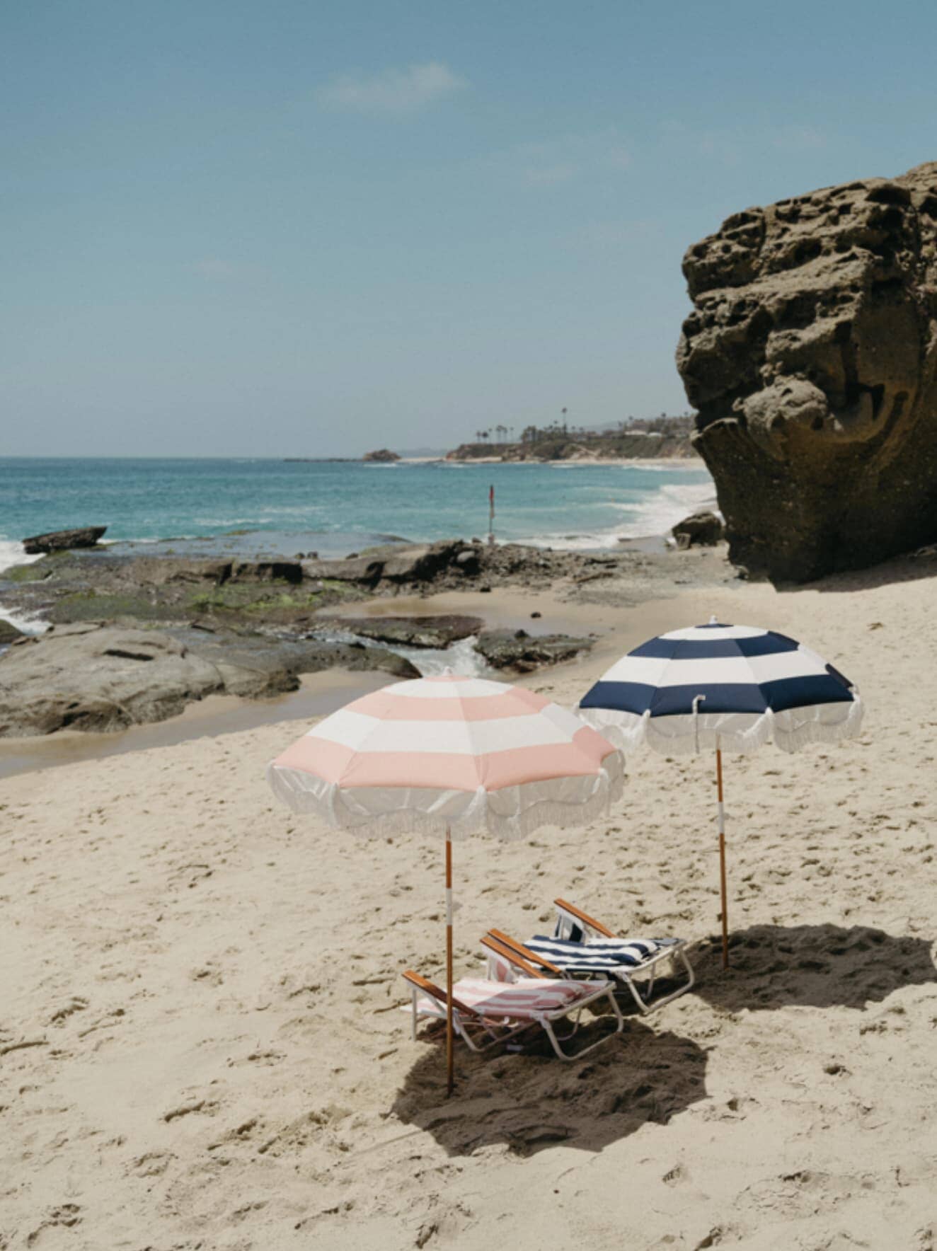 pink and navy holiday umbrellas on the beach