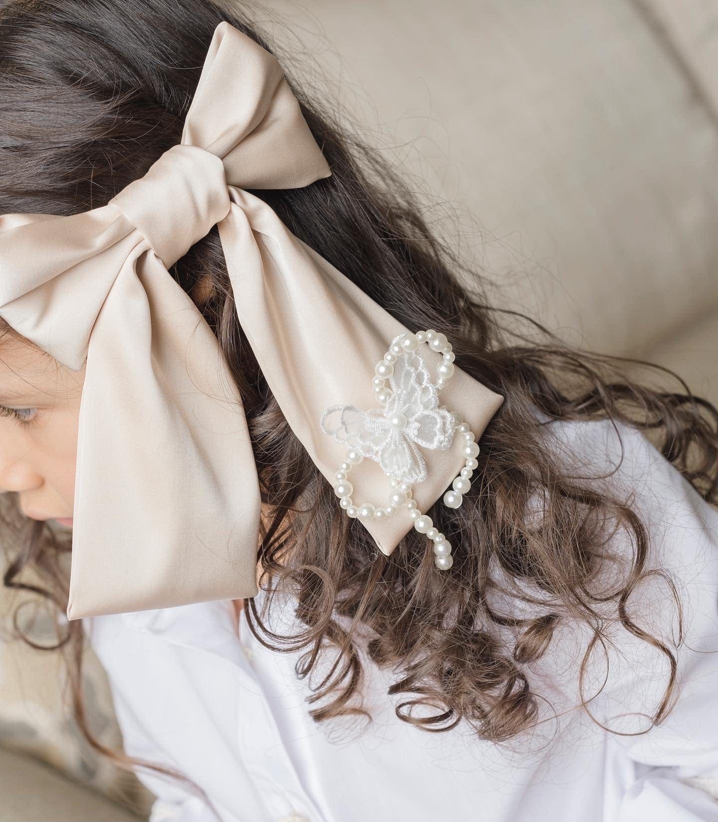 Close up view of Anise Satin Embroidered Hair Bow in champagne with butterfly detail