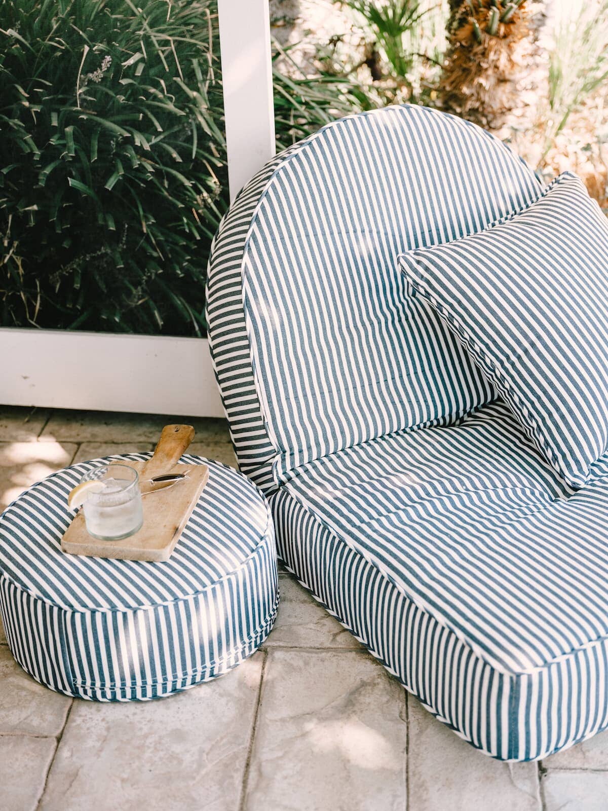 Lifestyle image of the reclining lounger on a patio with a drink