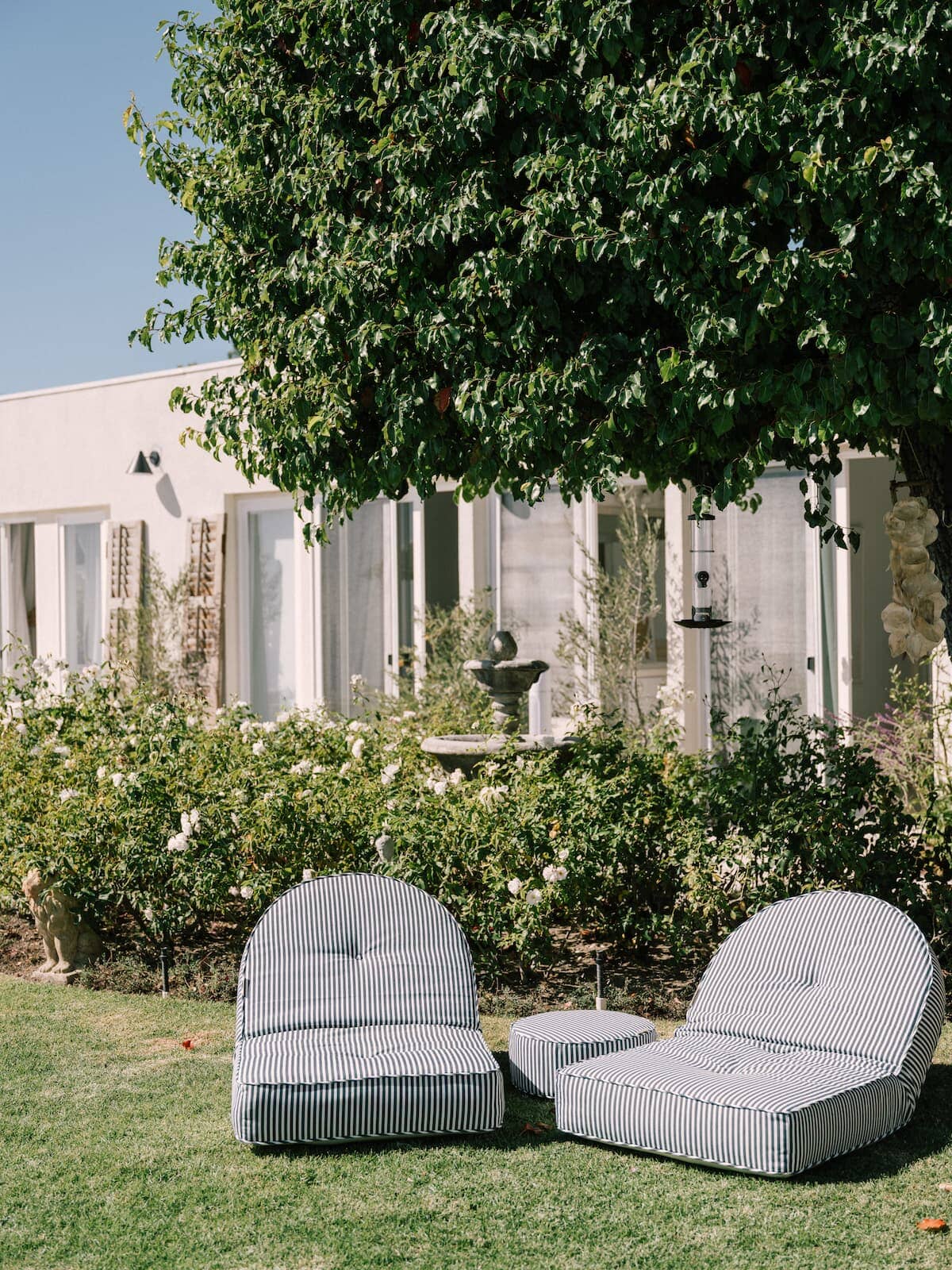 Lifestyle image of 2 reclining loungers in a garden setting