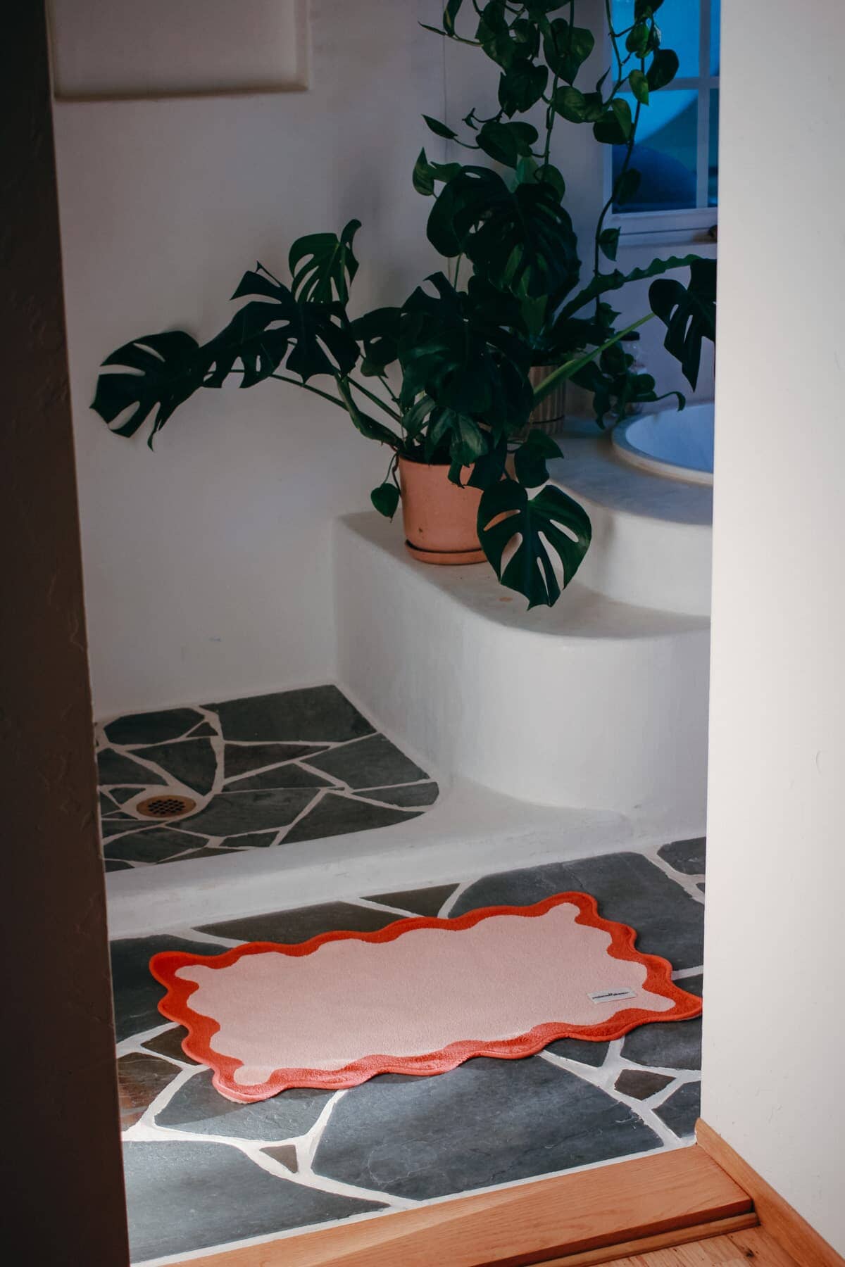 Pink bath mat on a stone floor