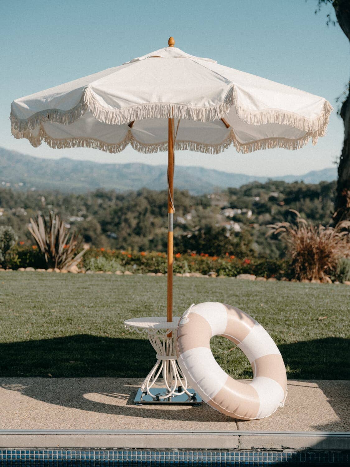 pink pool ring leaning against an outdoor umbrella