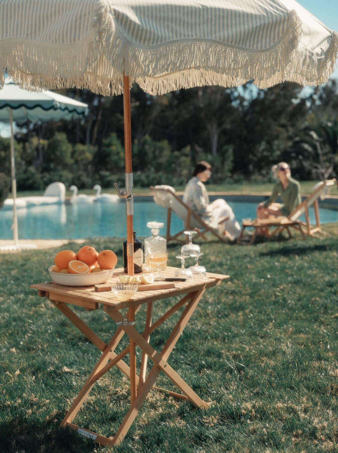 Outdoor picnic setting with tall folding table with drinks and fruit